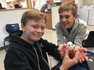 Students holding an egg
